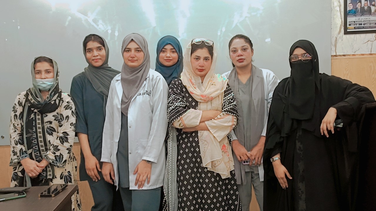 Students and clinical instructors standing together in a lecture room at Agha Institute of Health Sciences