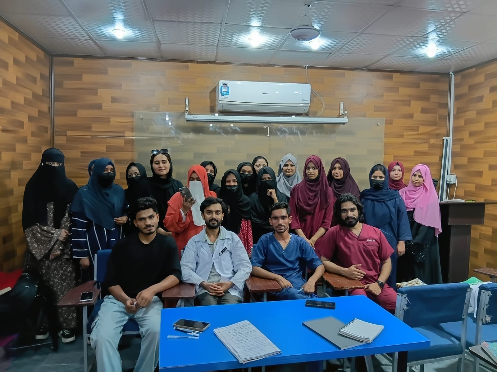 Male and female students seated and standing together during a classroom session at the Lahore campus
