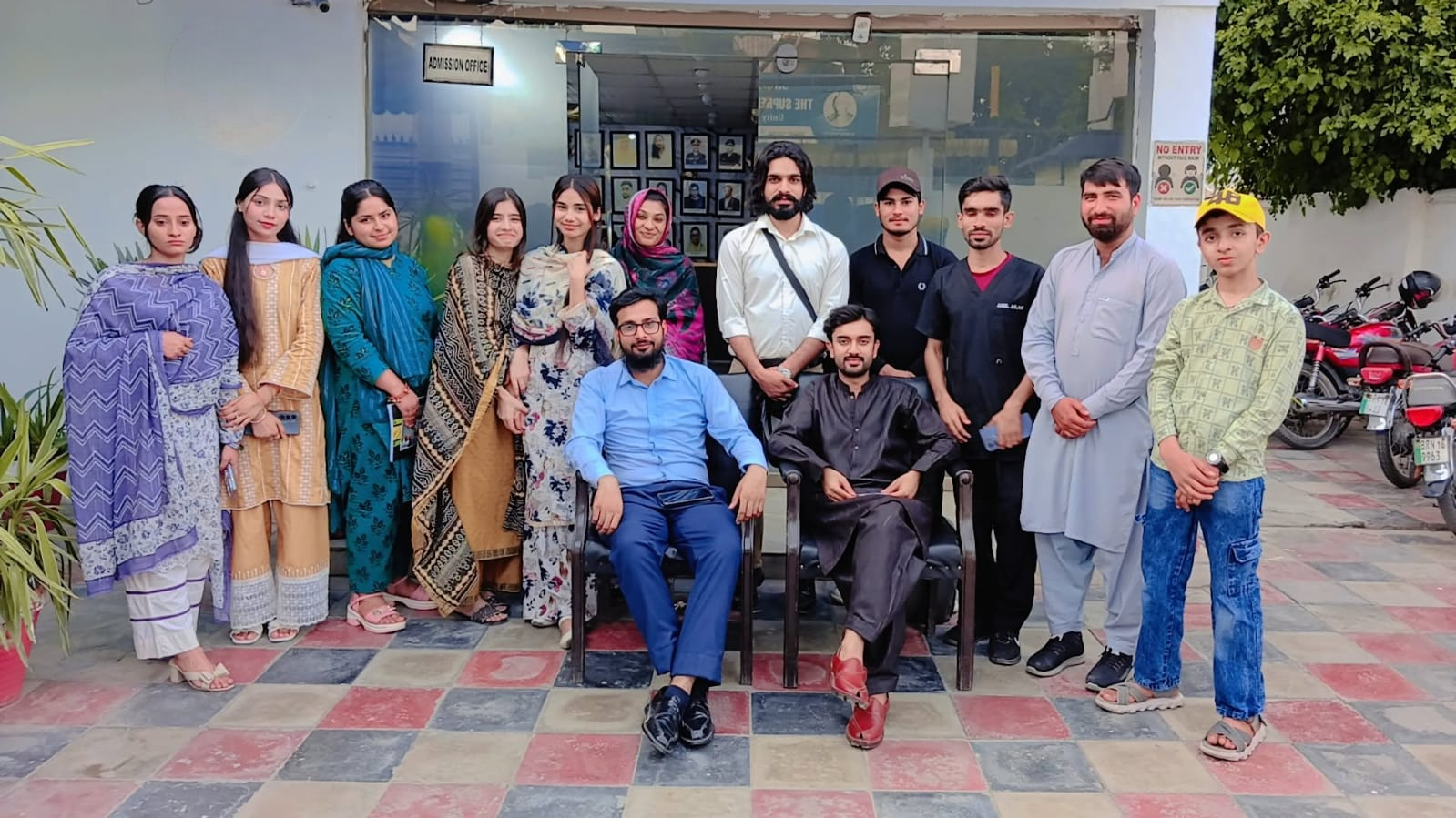 Students and faculty members photographed in the campus courtyard of Agha Institute of Health Sciences