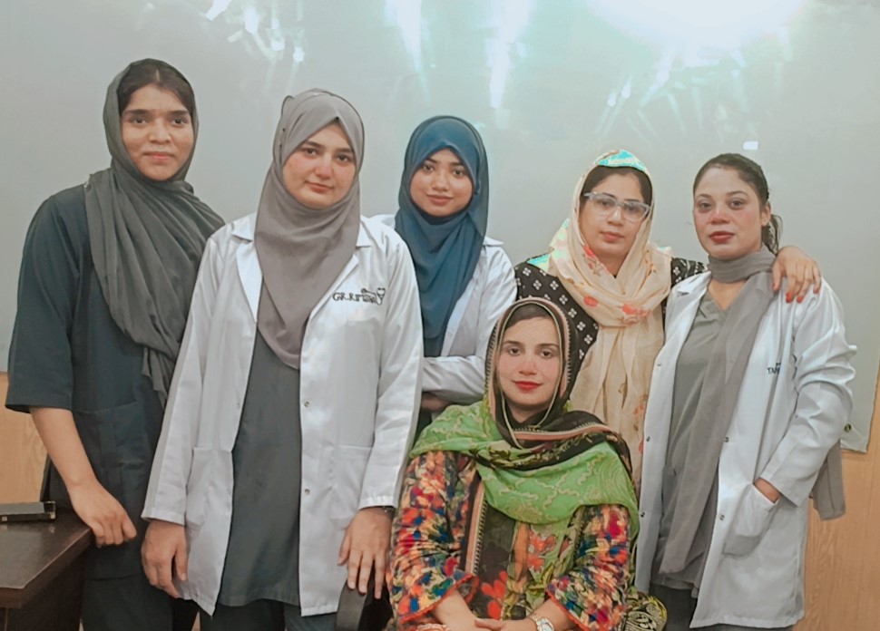 Group of female students in lab coats at Agha Institute of Health Sciences classroom in Lahore